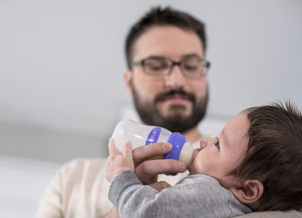 Padre alimenta a su bebé con biberón